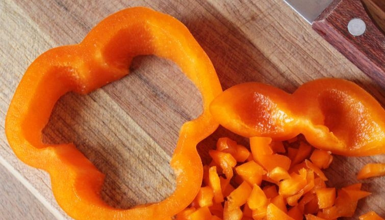 1. Этап. Интересный салат на день рождения: Теперь настал черед сладкого перца. Вымойте его, обсушите и разрежьте на две части. Достаньте семена и серединку с ножкой. Мякоть нарежьте на кубики небольшого размера.