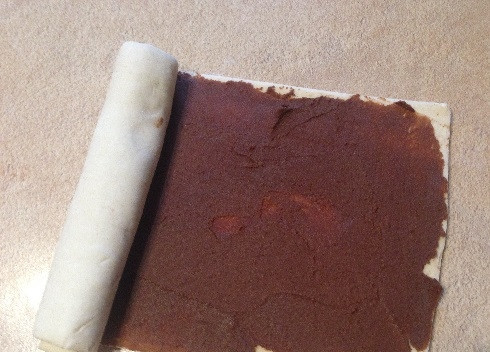 1. Этап. Печенье Слоновьи ушки: Пометим середину листа теста и скатываем один край теста с помадкой к середине. Затем точно так же скатываем второй край.