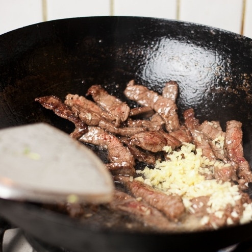 1. Этап. Говядина с брокколи: Когда говядина слегка обжарится и поменяет цвет, добавляем в вок имбирь и чеснок. Перемешиваем.