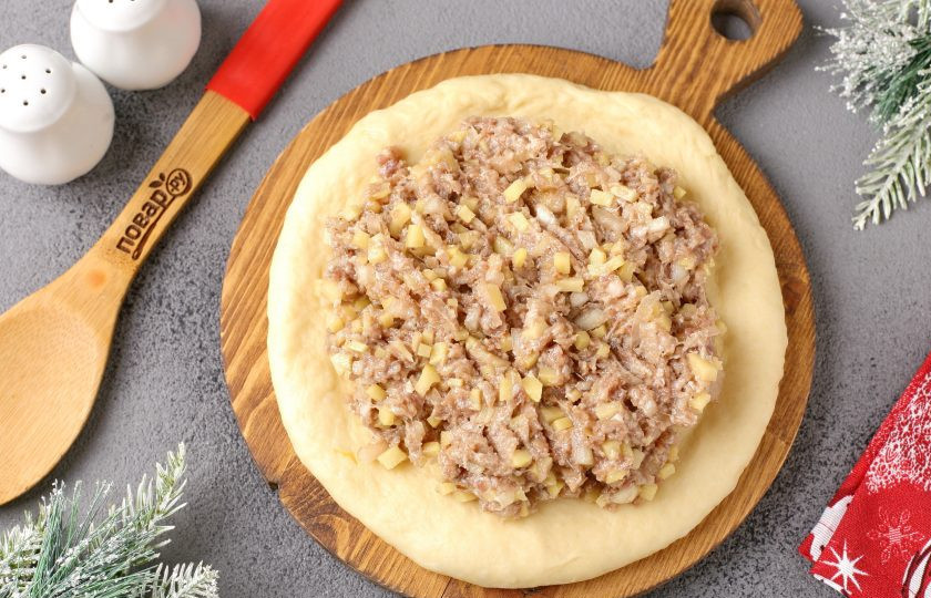 1. Этап. Мясной пирог Лапа тигра: Ту часть, что побольше, раскатайте в форме круга и выложите оставшуюся начинку.