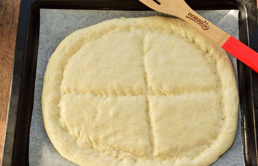 1. Этап. Матнакаш на кефире: Тыльной стороной ладони или рукоятью ножа сделайте углубления по краю и крестом по центру лепешки. Отправьте матнакаш в разогретую до 200 °C духовку на 15 минут до золотистой корочки.