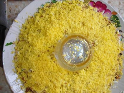 1. Этап. Салат Браслет: 8. Желтки натереть на терке или размять вилкой. Немного подсолить и выложить следующим слоем.