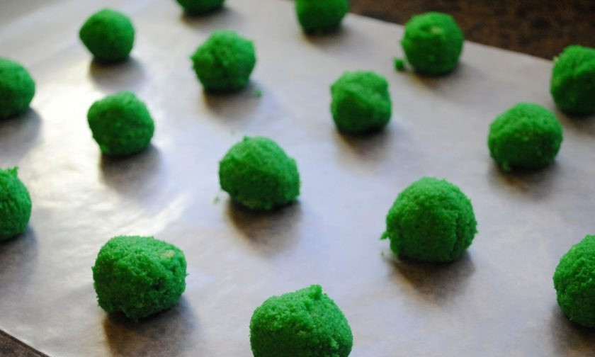 1. Этап. Кейкпопсы Рождественский сюрприз: Теперь из теста с сыром сделайте шарики одинакового размера. Выложите их на плоскую посуду с пергаментом. Уберите в холодильник на 10 минут.