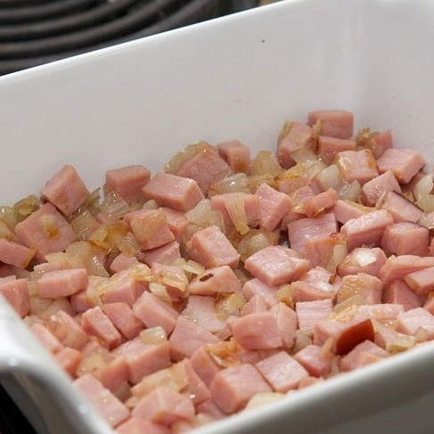 1. Этап. Яичница в духовке: Выкладываем обжаренные бекон и лук в форму для запекания.