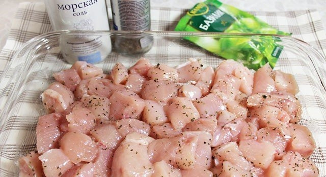 1. Этап. Тыква с курицей в духовке: Грудку промойте, обсушите и нарежьте небольшими кусочками. Перемешайте их с базиликом, ложкой масла и солью. Выложите курицу на дно формы для запекания.