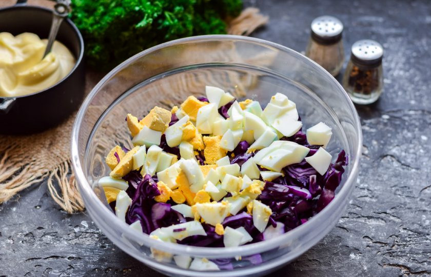 1. Этап. Салат с краснокочанной капустой и кукурузой: Куриное яйцо отварите, почистите и нарежьте кубиком. Добавьте яйцо к капусте.