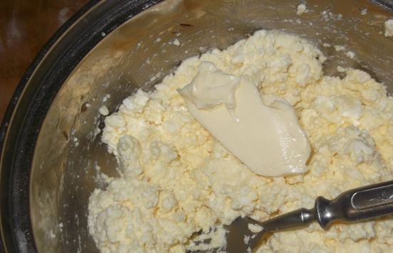 1. Этап. Творог для вареников: Достаньте масло из холодильника. Дайте ему время постоять в тепле, чтобы оно стало мягким. Добавьте масло в творожную начинку и тщательно все перемешайте. Если вы готовите сладкие вареники, то добавьте сахарную пудру по вкусу. Храните начинку в холодильнике не больше суток, а лучше — используйте по назначению сразу же после приготовления.