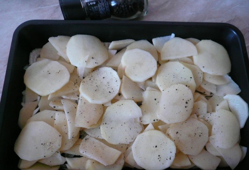 1. Этап. Запеченный картофель со свининой: 2. Поверх лука — картошку. Специи и соль — сюда же.