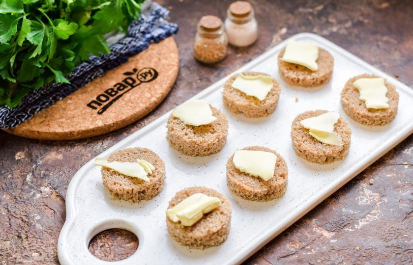 1. Этап. Канапе с килькой и яйцом: Каждый кусочек хлеба смажьте сливочным маслом.