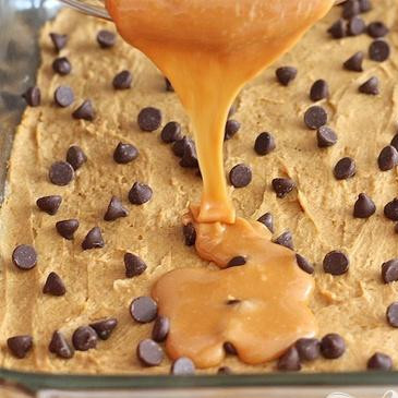 1. Этап. Тыквенные пирожные с карамелью и шоколадом: 4. Полить растопленной карамелью поверх шоколада и орехов. Разровнять равномерно столовым ножом или ложкой.