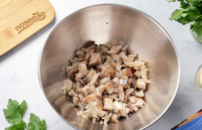 1. Этап. Салат со скумбрией и соленым огурцом: Отделите филе скумбрии от костей. Нарежьте небольшими кусочками и переложите в глубокую миску.