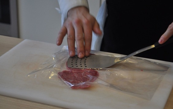 1. Этап. Карпаччо из говяжьей вырезки: Кусочки мяса оберните пищевой пленкой или же просто поместите в файлик формата А4. Отбейте говяжью вырезку лопаткой до полупрозрачного состояния. Благодаря пищевой пленке мясо останется целым и не разлезется.