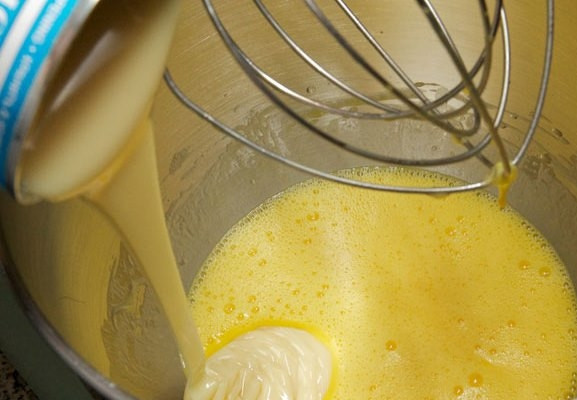 1. Этап. Простой Сметанник: Добавьте сгущенное молоко и продолжайте взбивать.