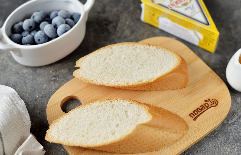 1. Этап. Тост с голубикой и сыром Бри: Нарежьте булку удобными ломтями толщиной 1,5-2 сантиметра.