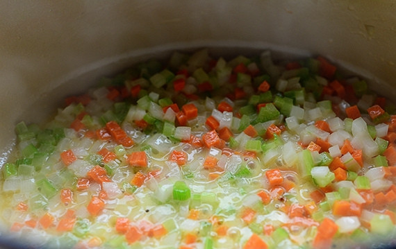 1. Этап. Пирог в горшочке с курицей и овощами: 1. Растопите сливочное масле в алюминевой кастрюле, насыпьте в нее измельченный лук, морковь и сельдерей. Готовьте овощи в течение трех минут, пока лук не станет прозрачным.