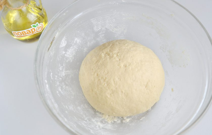 1. Этап. Дрожжевые лепешки с луком: 5. Когда тесто начнет собираться в ком, переложите его на стол и домесите руками еще 5-6 минут. При этом муку добавлять не нужно, должен получиться пластичный мягкий колобок. Накройте тесто салфеткой, поставьте в теплое место на 1 час.