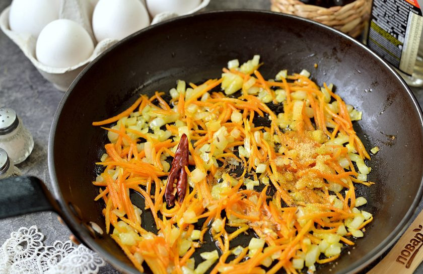 1. Этап. Плов на льняном масле с яйцами: Когда овощи хорошо прожарятся, добавьте к ним щедрую щепотку зиры, острый перчик и приправу для плова.