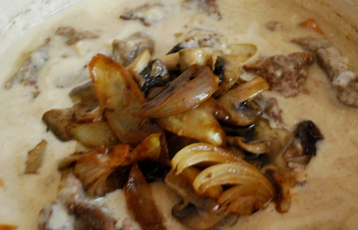 1. Этап. Тушеная телятина с грибами: Затем выкладываем в сотейник с мясом карамелизированный лук, снова все перемешиваем.