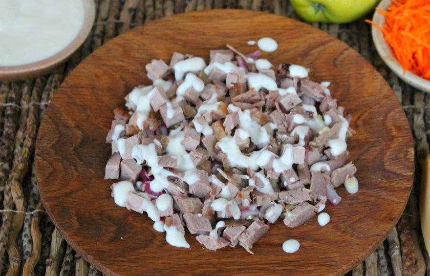 1. Этап. Французский салат на Новый год: Буженину нарезаем небольшими кусочками и кладем на лук. Добавляем салатную заправку на основе натурального йогурта.
