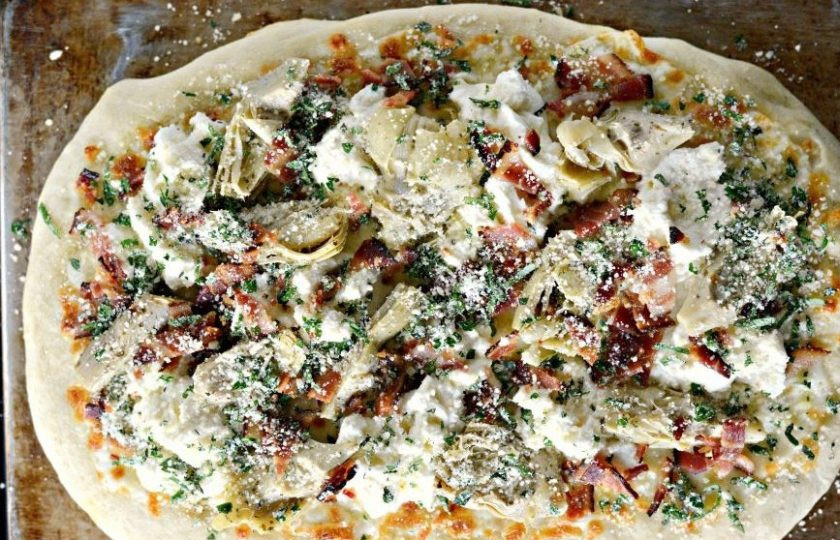 1. Этап. Пицца с беконом и артишоками: 3. После этого выложите рикотту, кусочки обжаренного бекона и дольки артишоков. Также посыпьте начинку пармезаном, измельчённым базиликом и петрушкой, а ещё – орегано.