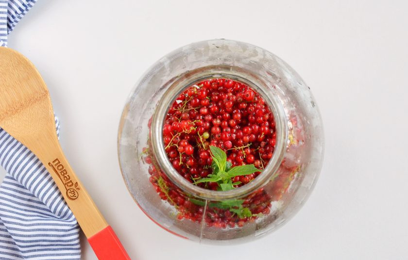 1. Этап. Компот из красной смородины на зиму: В стерильную банку выложите смородину, веточку мяты.