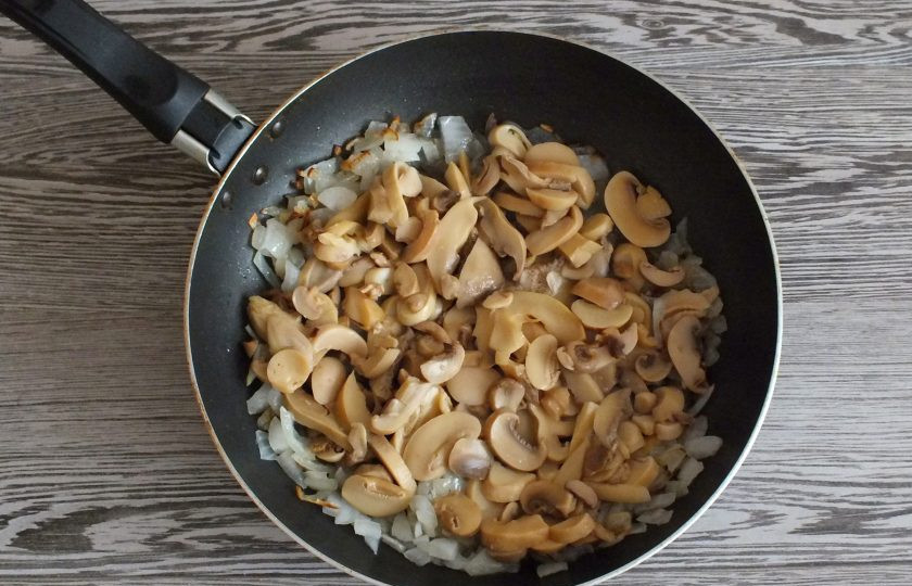 1. Этап. Энчиладос с курицей в лаваше: Когда лук станет мягким и начнёт зарумяниваться, добавьте грибы. Обжаривайте до выпаривания жидкости.