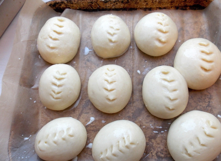 1. Этап. Японские молочные булочки Хокайдо: Переложите заготовки на противень, застеленный бумагой для выпечки и поставьте на 30 мин. в теплое место на расстойку. Смешайте яичный желток со сливками, смажьте и сделайте ножницами надрезы на поверхности. Оставьте еще на 10-15 мин.