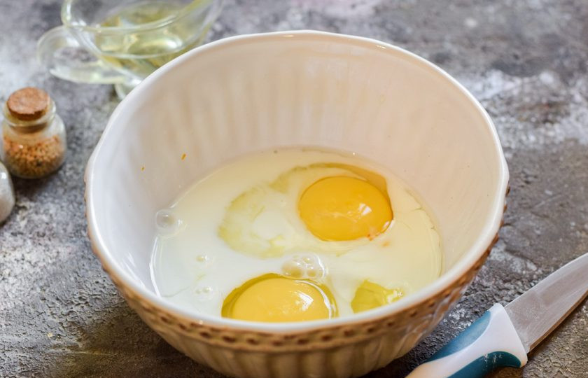 1. Этап. Запеканка из курицы и тыквы: Куриные яйца вбейте в глубокую миску, добавьте молоко, соль и перец по вкусу.