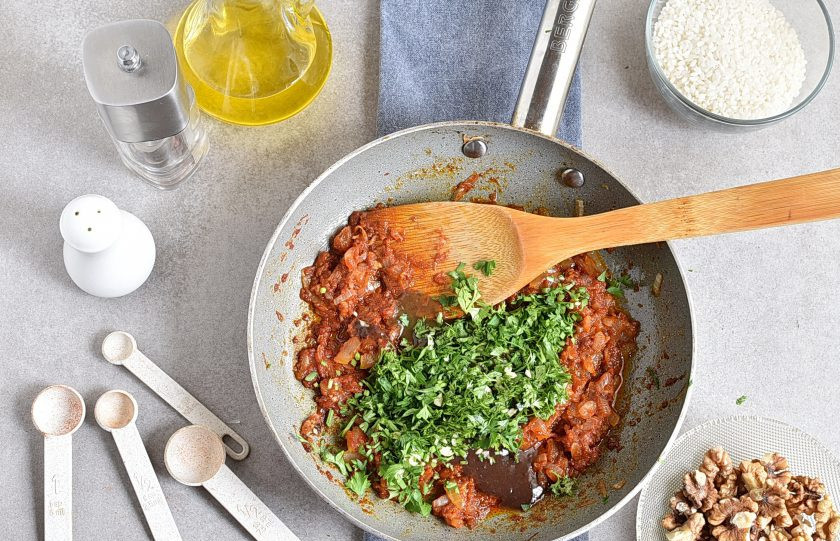 1. Этап. Харчо из говядины с ткемали: Добавьте в сковороду ткемали и половину нарезанной зелени. Отставьте в сторонку.