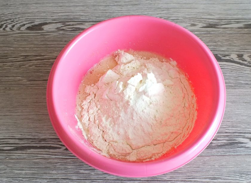 1. Этап. Пирог с творогом и сгущенкой: Добавьте муку, разрыхлитель для теста. Начните замес теста ложкой. Как только трудно станет мешать ложкой, месите руками.