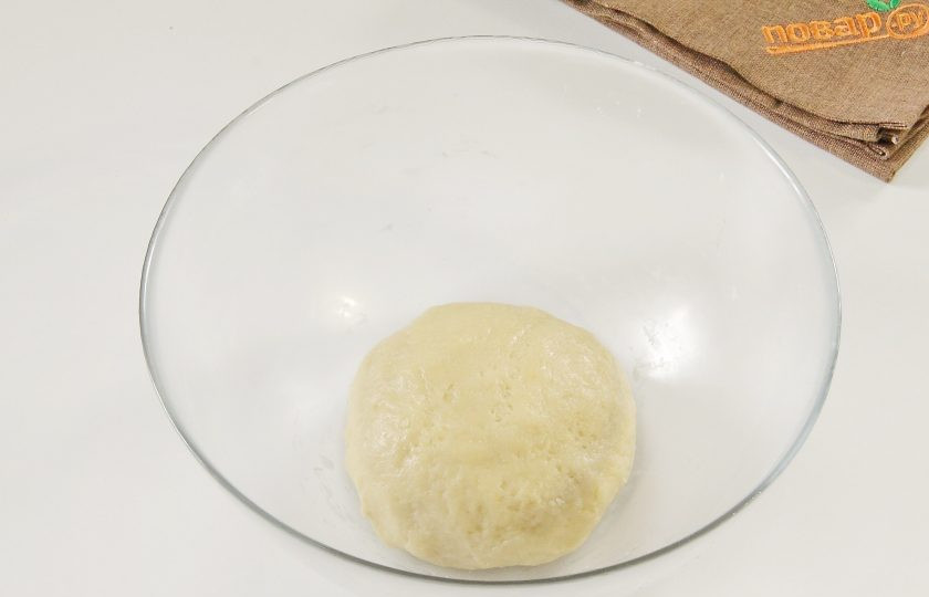 1. Этап. Пирог-перевертыш с киви и кедровыми орешками: Замесите мягкое тесто. Если необходимо, можно добавить еще немного муки, тесто не должно прилипать к рукам. Соберите его в шар, заверните в пленку и уберите в холодильник на 30 минут.