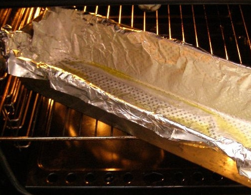 1. Этап. Тунец в духовке: 3. Возьмите небольшой глубокий противень или форму для запекания, застелите фольгой. Налейте в него немного масла и разогрейте.