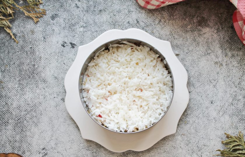 1. Этап. Салат Черное море: Яичный белок натрите на средней терке и распределите его на крабовые палочки с желтком. Белок оставьте в пушистом виде.