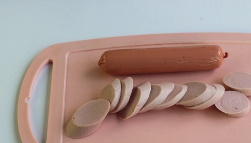 1. Этап. Багет запеченный с яйцом и сосисками: Сосиски нарежьте небольшими кусочками. Нарежьте мелко зелень, это может быть укроп, петрушка или зеленый лук.