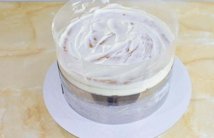 1. Этап. Медовик с малиной: Оберните торт ацетатной пленкой и затяните в кольцо. Верхний корж прижмите, чтобы начинка внутри распределилась более равномерно. Уберите торт в холодильник на ночь.