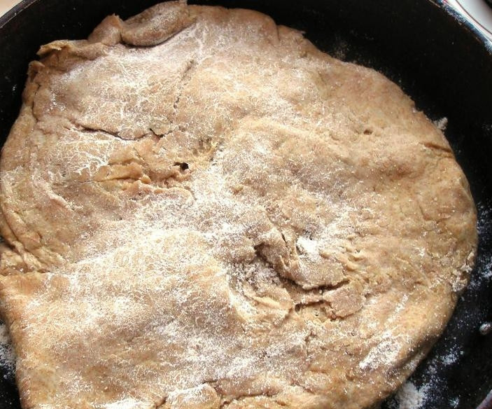 1. Этап. Здоровый хлеб: Чугунную сковороду или форму для выпечки присыпьте мукой. Распределите в ней тесто.