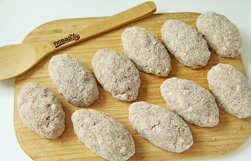 1. Этап. Котлета по-хлыновски: Сформируйте овальные котлеты и обваляйте их со всех сторон в сухарях.