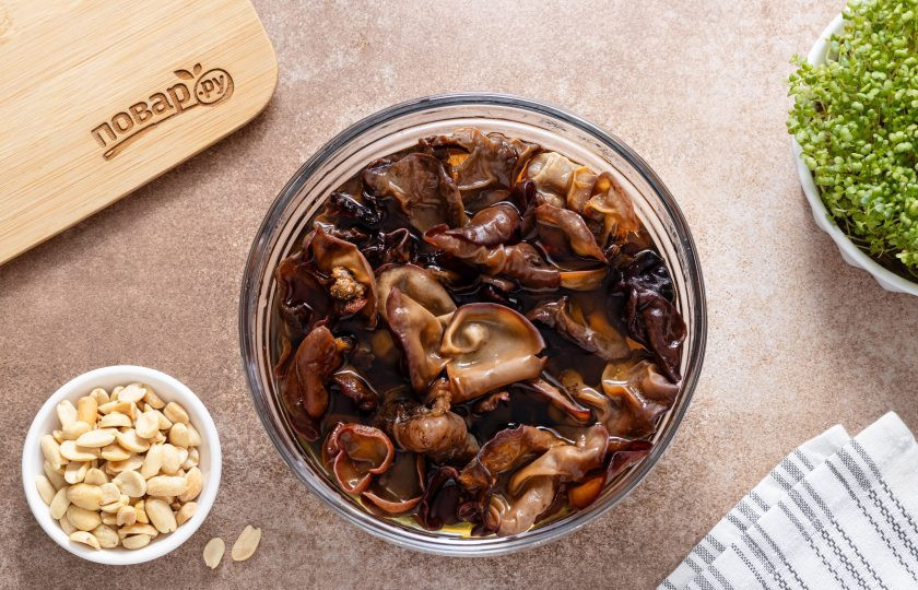 1. Этап. Закуска с древесными грибами и арахисом: Сушеные древесные грибы залейте горячей водой и оставьте на полчаса или больше.