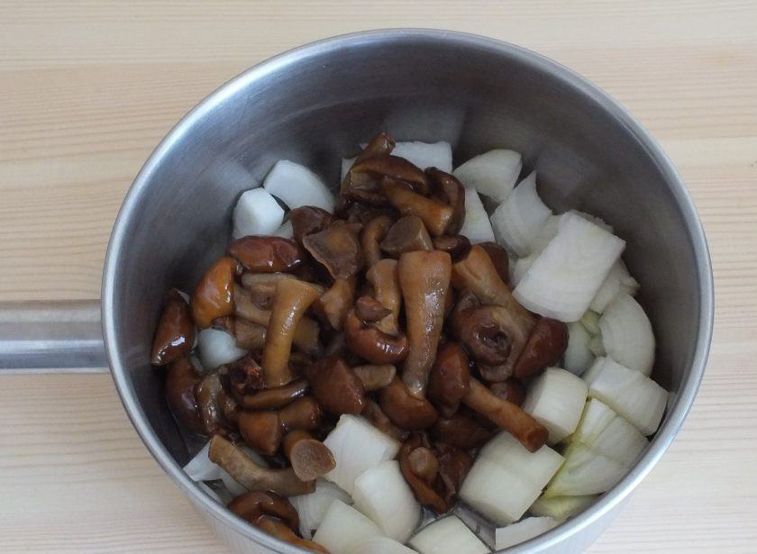 1. Этап. Икра из опят через мясорубку: В сотейнике или сковороде разогрейте растительное масло и выложите туда грибы и лук.