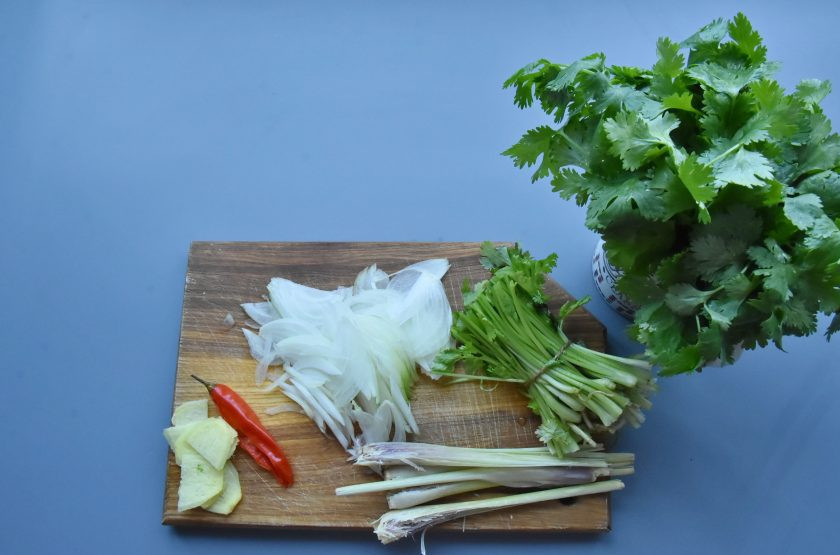 1. Этап. Суп Том ям с мидиями: Подготовьте продукты для вкусовой основы бульона. Чили разрежьте вдоль пополам и удалите семена. Лемонграсс раздавите плоской стороной ножа и разрежьте стебли вдоль. Имбирь очистите и нарежьте крупными кусочками. Отрежьте стебли кинзы, перевязав их нитью. Зелень оставьте для подачи блюда. Лук нарежьте перьями.