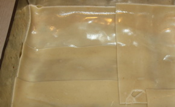 1. Этап. Лазанья без соуса Бешамель: Сверху соуса уложите слой отваренных листьев лазаньи.