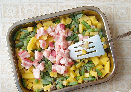 1. Этап. Запеченные свиные ребрышки с овощами: 4. Спассерованые грибы выкладываем в противень, туда же ложем кусочки сала и мяса, стручковую фасоль и картофель.