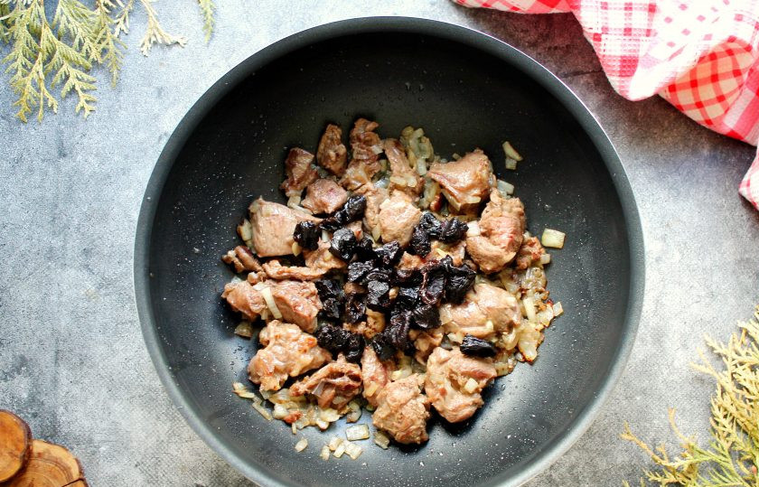 1. Этап. Эсик флейш: Убавьте огонь до среднего. Чернослив разрежьте пополам и добавьте к мясу.