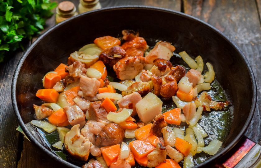 1. Этап. Суп с копченостями и вермишелью: Сковороду разогрейте и выложите бекон, копченую курицу, морковь и лук — жарьте 3 минуты, помешивая.