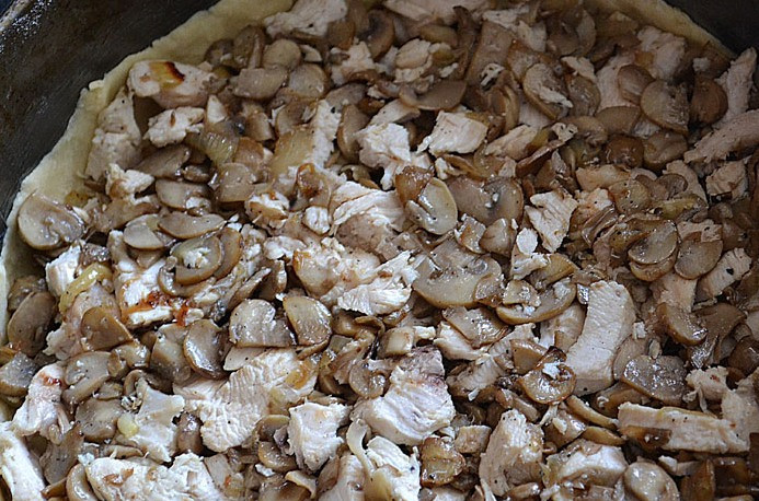 1. Этап. Лоранский пирог с курицей и грибами: Теперь мы раскатываем тесто в круглый пласт и аккуратно переносим его в разъемную форму, смазанную сливочным маслом, из краев теста делаем небольшие бортики. Выкладываем на дно формы приготовленную начинку и равномерно ее распределяем.