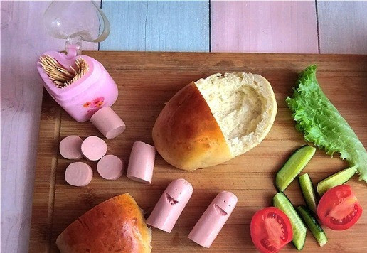 1. Этап. Бутерброд Весёлые сосиски: Одну сосиску разрежем пополам. Вырежем улыбающийся ротик и зубочисткой сделаем глазки. Из второй сосиски нарежем к автомобилю колёсики. Приготовим зубочистки, чтобы закрепить 