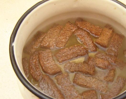 1. Этап. Квас в домашних условиях из хлеба: 3. Вскипятите воду из расчета на 100 граммов сухарей до 2л. воды (минимум 1,5 литра). Бросаем в кипяток наши сухари, оставляем их часа на 4-5. После этого добавляем сахар и сухие дрожжи, после чего накрываем емкость (лучше крышкой) и оставляем её в теплом месте до полного созревания на несколько дней.