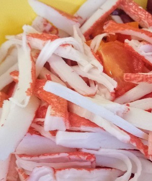 1. Этап. Крабовые палочки с фасолью: Разобрать крабовые палочки на волокна и выложить в салатницу. Волокна будут визуально напоминать краба.