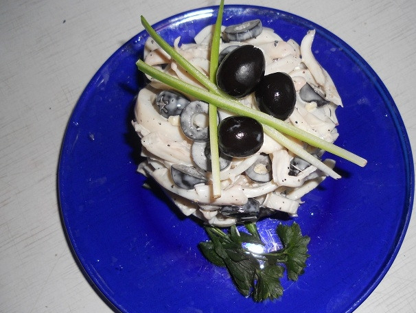 1. Этап. Салат из кальмаров и оливок: Салат из кальмаров и оливок украсьте оливками и свежей зеленью. Приятного аппетита.