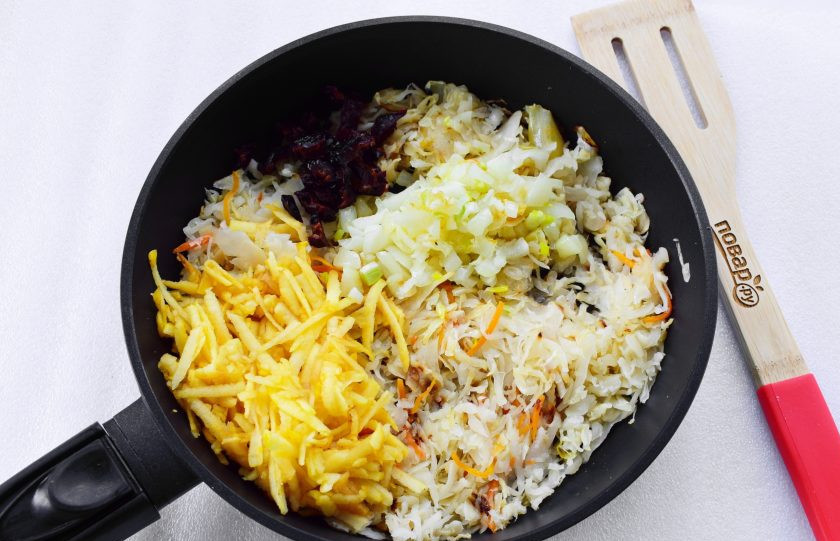 1. Этап. Картопляники с постной начинкой: На разогретом масле обжарьте лук до прозрачности, добавьте квашеную капусту и тушите на медленном огне в течение 10 минут. Добавьте тертое яблоко и измельченный чернослив, перемешайте и прогрейте минуту на слабом огне.